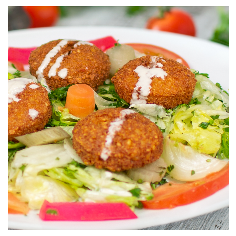 Introducing the Falafel Salad from Tayybeh: Enjoy three chickpea falafel balls served on a bed of shredded lettuce, accompanied by pickled vegetables and topped with a creamy tahini sauce.