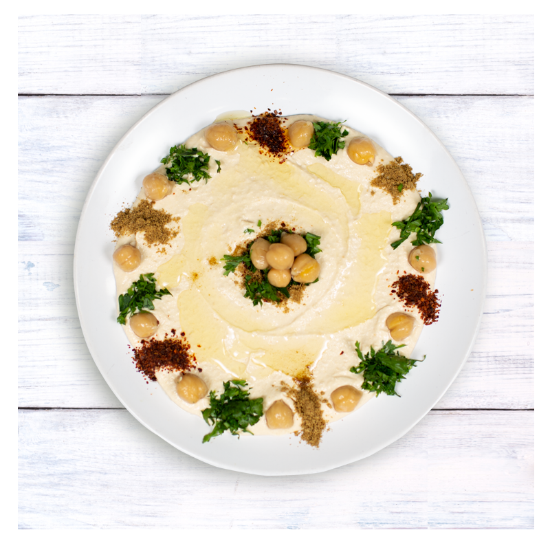 A gluten-free Tayybeh hummus dip topped with chickpeas, parsley, spices, and a swirl of olive oil.