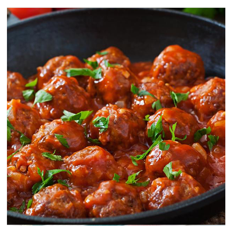 Savory kebabs in a tomato sauce, garnished with fresh herbs, presented in a black pan. Brought to you by Tayybeh.