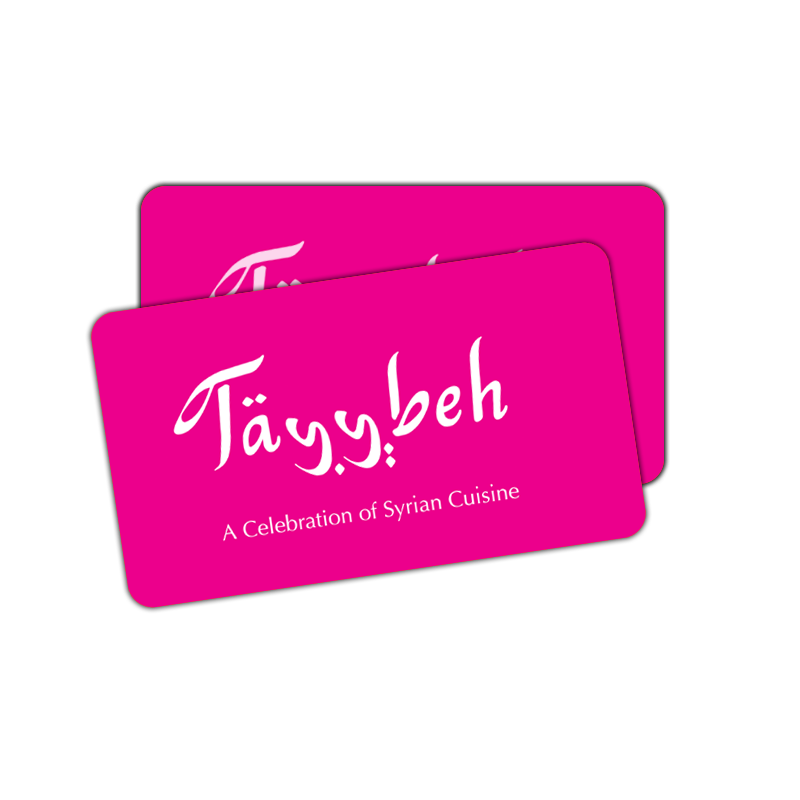 A pair of vibrant pink Tayybeh E-Gift Cards, elegantly featuring the brand name "Tayybeh: A Celebration of Syrian Cuisine" in white, make an ideal gift for your loved ones.